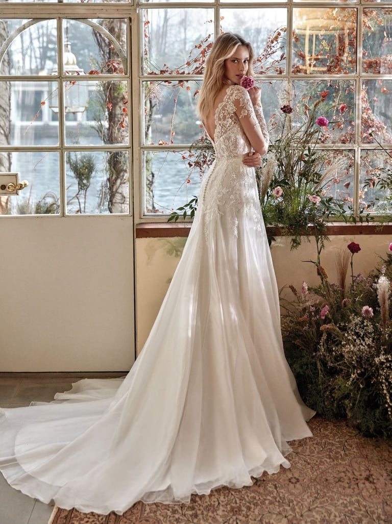 Novia con vestido de encaje y gasa en invernadero con flores