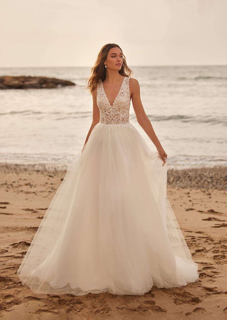 Novia con vestido blanco con beads en playa con océano